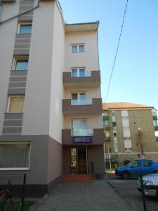 a building with a car parked in front of it at Hostel Lan in Oradea