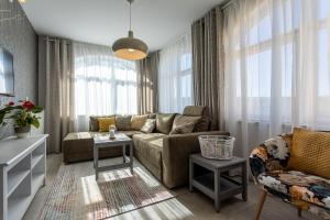 a living room with a couch and some windows at Pansion Tina in Šilo