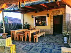 un patio con tavoli e panche in legno su una casa di Apartmán Marie a Mutěnice