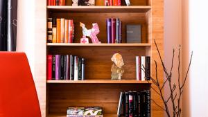 a book shelf filled with books and stuffed animals at BIO-Hotel Villa Orange in Frankfurt