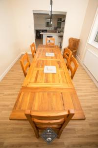 a long wooden table with chairs and a kitchen at Celtic House in Merthyr Tydfil
