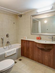 a bathroom with a toilet and a tub and a sink at Marina View One Bedroom Dream Suite in Herzelia 