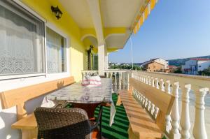 a balcony with a table and chairs and a window at Apartments Boza in Lopar