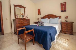 a bedroom with a bed and a chair and a mirror at La Maison de la Plage, by Comfortable Luxury in Corralejo
