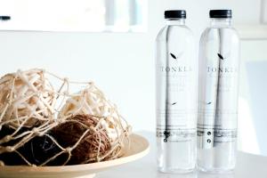 two bottles of water and a basket on a table at Tonkla Boutique Hotel in Lamphun