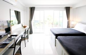 a bedroom with a bed and a desk with a computer at Tonkla Boutique Hotel in Lamphun