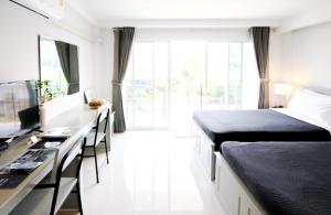 1 dormitorio con 1 cama y escritorio con ordenador en Tonkla Boutique Hotel en Lamphun