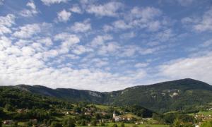 un pueblo en las montañas bajo un cielo nublado en Hôtel Pierre Blanche en Châtillon-en-Michaille