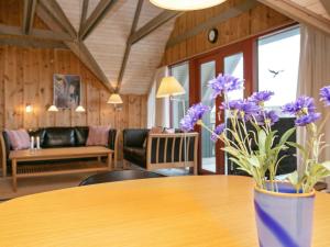 a vase of purple flowers sitting on a table at 6 person holiday home in Hvide Sande in Bjerregård