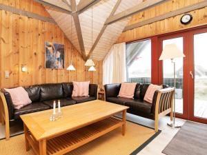 a living room with a couch and a table at 6 person holiday home in Hvide Sande in Bjerregård