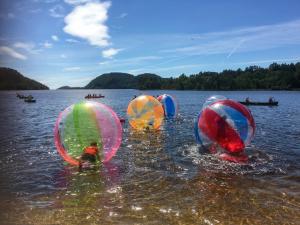 a group of people playing in colorful balls in the water at Solstrand Camping in Vigeland