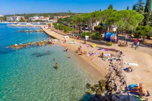 grupa ludzi na plaży w wodzie w obiekcie Apartment Marohnić w mieście Malinska