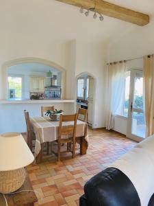 a living room with a table and a kitchen at Maison La Plaine in Lourmarin