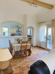 a living room with a table and a kitchen at Maison La Plaine in Lourmarin +12 photos