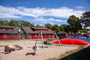 um parque com um parque infantil com escorrega e baloiços em Solstrand Camping em Vigeland