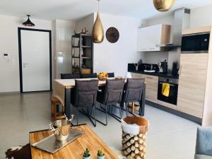 Appartement cocooning - Grande terrasse - bain nordique-Sauna - DOMAINE DU PATRE في فوياني: مطبخ مع طاولة وكراسي في غرفة