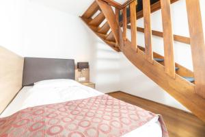 Un pat sau paturi într-o cameră la Hotel Alexander