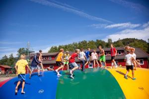 um grupo de crianças brincando em um trampolim em Solstrand Camping em Vigeland