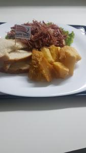 a white plate with a sandwich and some food on it at Happy Night (Adults Only) in Cotia