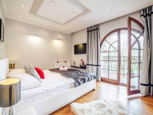um quarto com uma cama branca e uma grande janela em Apartamenty Sienkiewicza 12 em Zakopane