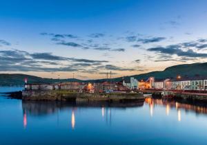 een uitzicht op een haven 's nachts met een stad bij Londonderry Arms Hotel in Carnlough