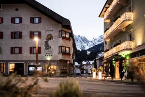 a street in a town with buildings and a mountain at Post Residence in San Candido