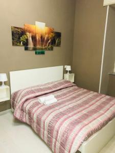 ナポリにある'A Funtanellaのベッドルーム1室(ストライプ掛け布団付きのベッド1台付)
