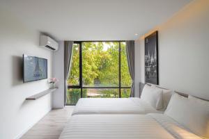 a hotel room with a bed and a large window at Amarin Hotel Rama 8 in Bangkok