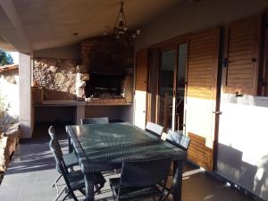 een patio met een tafel en stoelen op een veranda bij casa-lesia in Porto-Vecchio