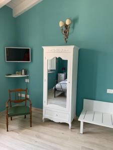 a blue room with a mirror and a chair at B&B Nonna Teresa in Roverbella