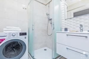 コウォブジェクにあるJantar Apartamenty Bliżej Morzaのバスルーム(シャワー付)の洗濯機が備わります。