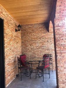 a patio with two chairs and a table in a brick wall at Cozy Place in Kazbegi in Kazbegi