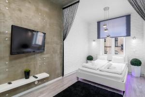 ポズナンにあるSleepway Apartments - Grey Dreamのリビングルーム(白いソファ、薄型テレビ付)