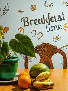 una mesa con naranjas para plátanos y un plato de fruta en Wake Up Weligama en Weligama