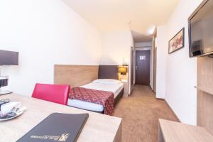Un pat sau paturi într-o cameră la Hotel Alexander