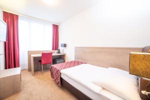 Un pat sau paturi într-o cameră la Hotel Alexander