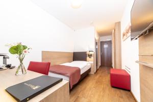 Un pat sau paturi într-o cameră la Hotel Alexander