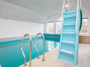 uma piscina com um escorrega azul num quarto em 16 person holiday home in Ulfborg em Ulfborg