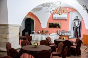 a room with tables and chairs and a statue in the background at Zamek w Krasiczynie in Krasiczyn