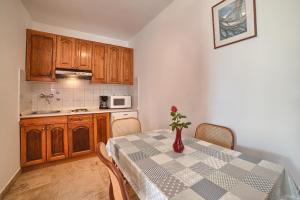 a kitchen with a table with a vase on it at Apartment Villa Mare1 with pool, sea view and hydromassage in Banjole