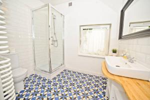 a bathroom with a shower and a sink and a toilet at White Sand Apartment Centrum by Grand Apartments in Sopot +5 photos