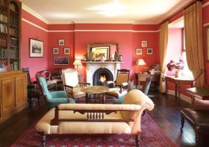 a living room with red walls and a fireplace at Lough Inagh Lodge Hotel in Recess