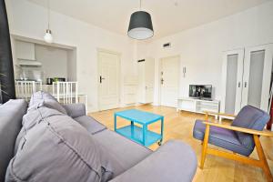a living room with a couch and a blue table at White Rock Apartment by Grand Apartments in Sopot