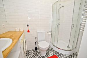 a bathroom with a shower and a toilet and a sink at White Rock Apartment by Grand Apartments in Sopot +2 photos