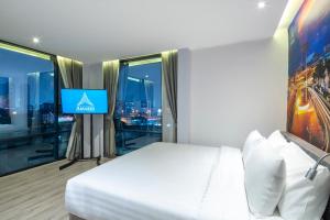 a hotel room with a bed and a tv at Amarin Hotel Rama 8 in Bangkok