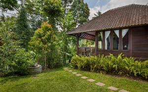 een huis met een tuinhuisje in een tuin bij Secluded Jungle Villa in Ubud