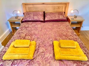 a bedroom with a bed with two yellow cushions on it at Hawkshead Cottage in Glossop
