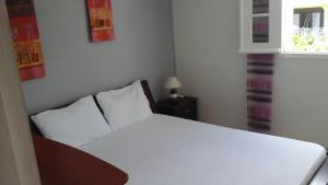 um quarto com uma cama branca e uma janela em Appartement les pieds dans l'eau em Le Gosier