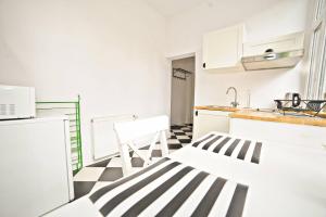 a kitchen with a black and white checkered floor at White Marina Apartment by Grand Apartments in Sopot +3 photos