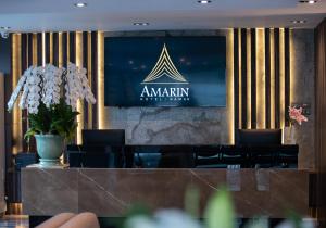 a tv on a wall with aania sign on it at Amarin Hotel Rama 8 in Bangkok
